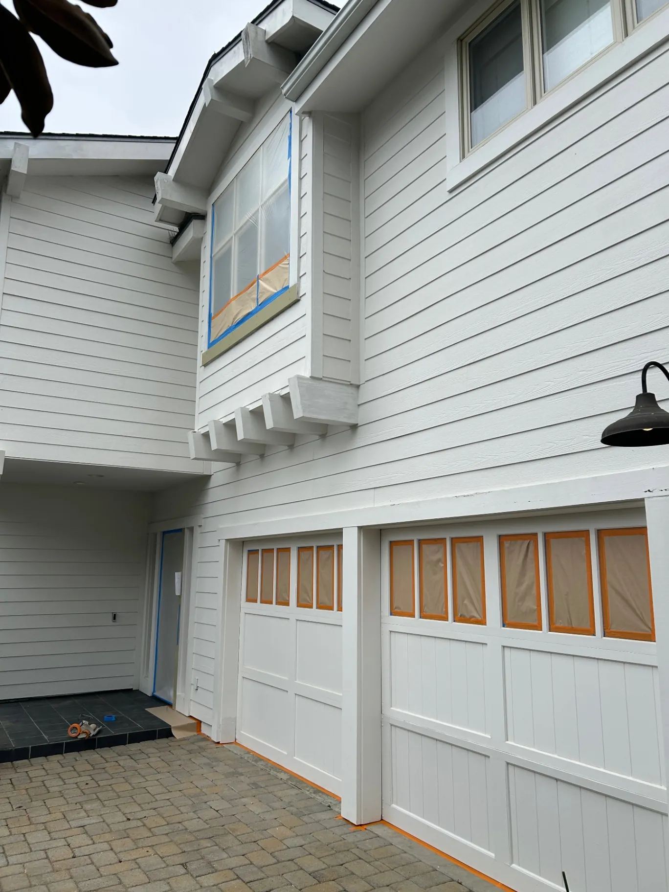 Garage doors and second-story siding masked off mid-project