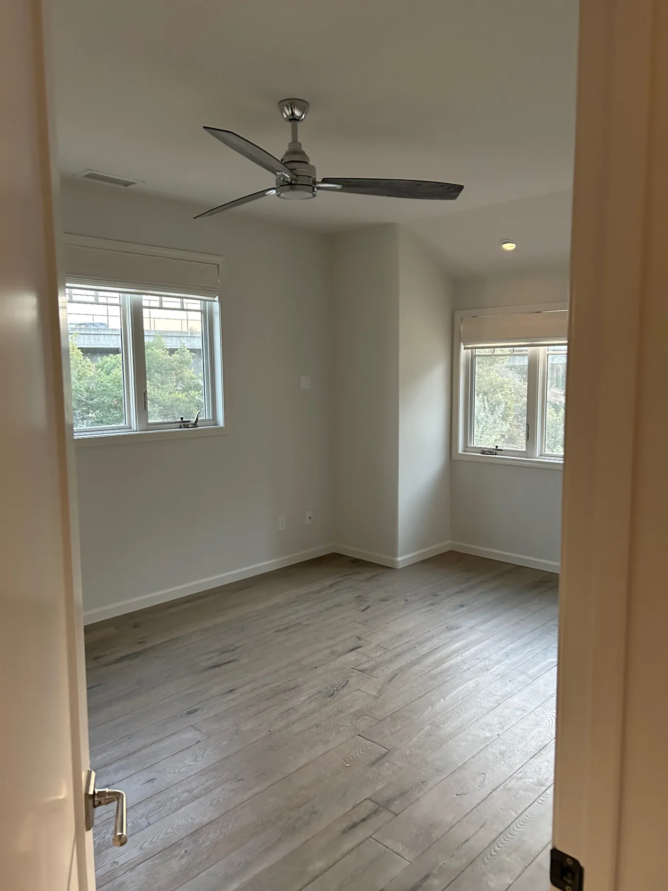 Bright bedroom with white walls and wood floors