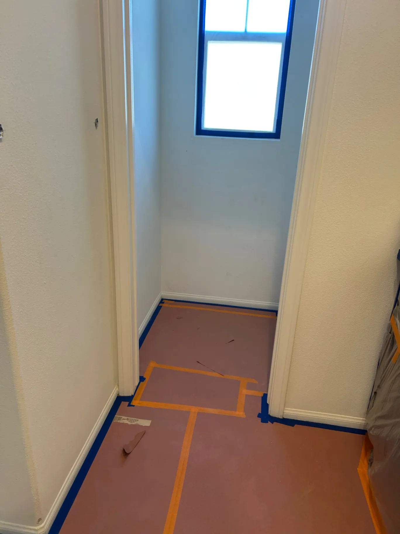 Hallway with floors fully masked and prepped before painting