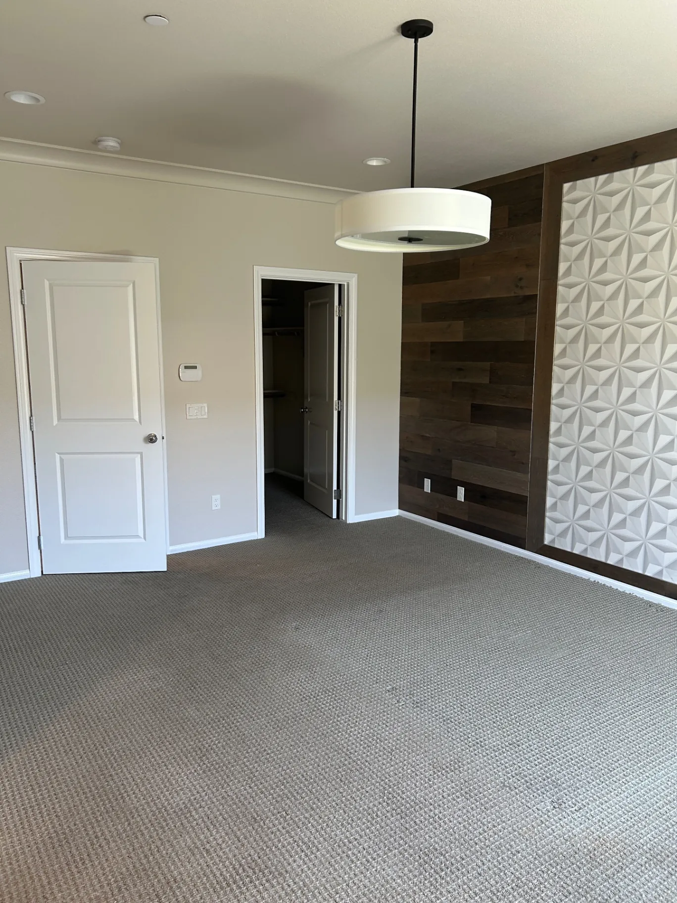 Bedroom with neutral walls, wood accent wall and 3D tile feature