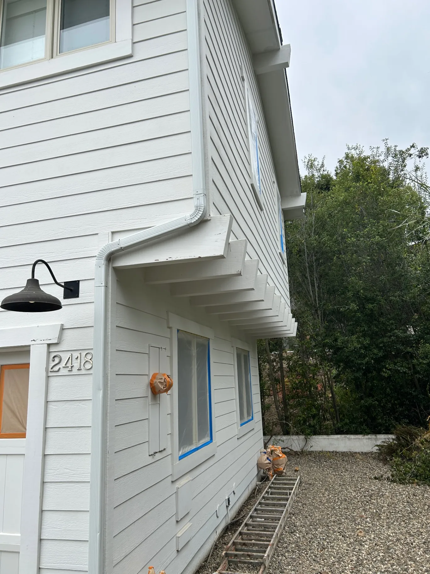 Detail of freshly painted siding, gutter and exposed rafter tails
