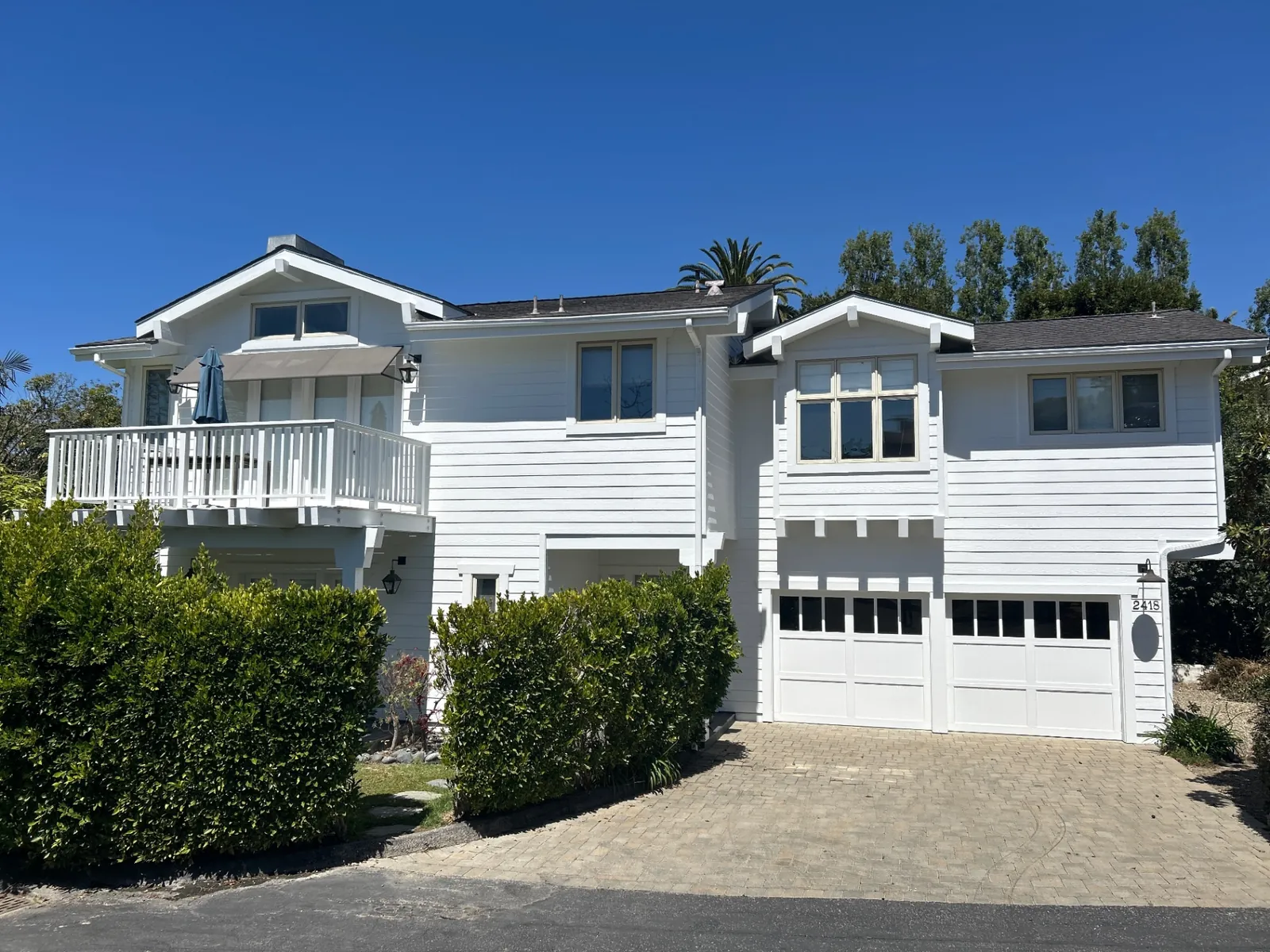 Finished white Craftsman home with fresh exterior paint and dark roof