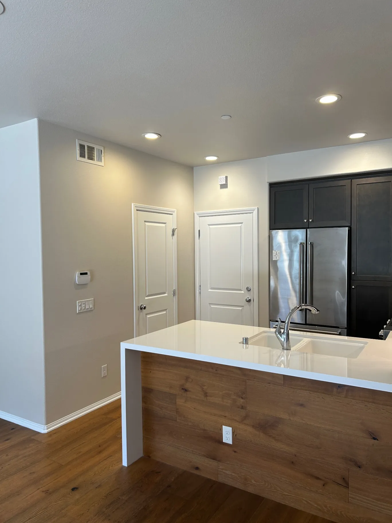 Open kitchen with warm gray walls, white ceiling and dark cabinetry