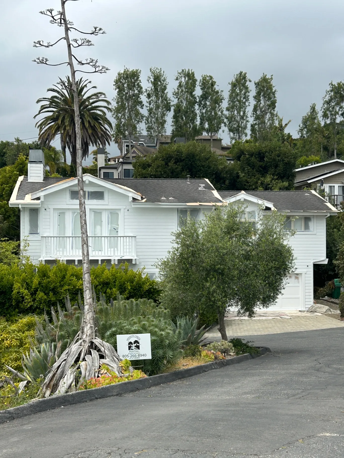 Side view of home with Mission Creek Painting yard sign during repaint