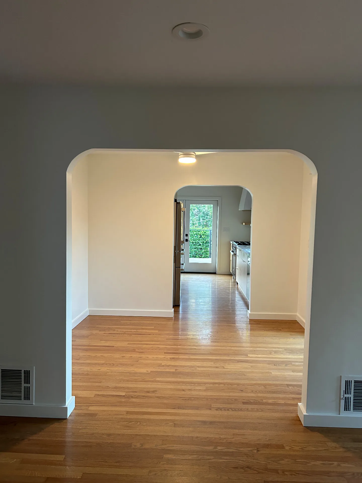 Arched hallway with newly painted walls leading to the kitchen